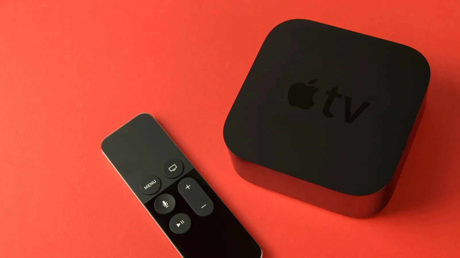 Apple TV box and remote on an orange background